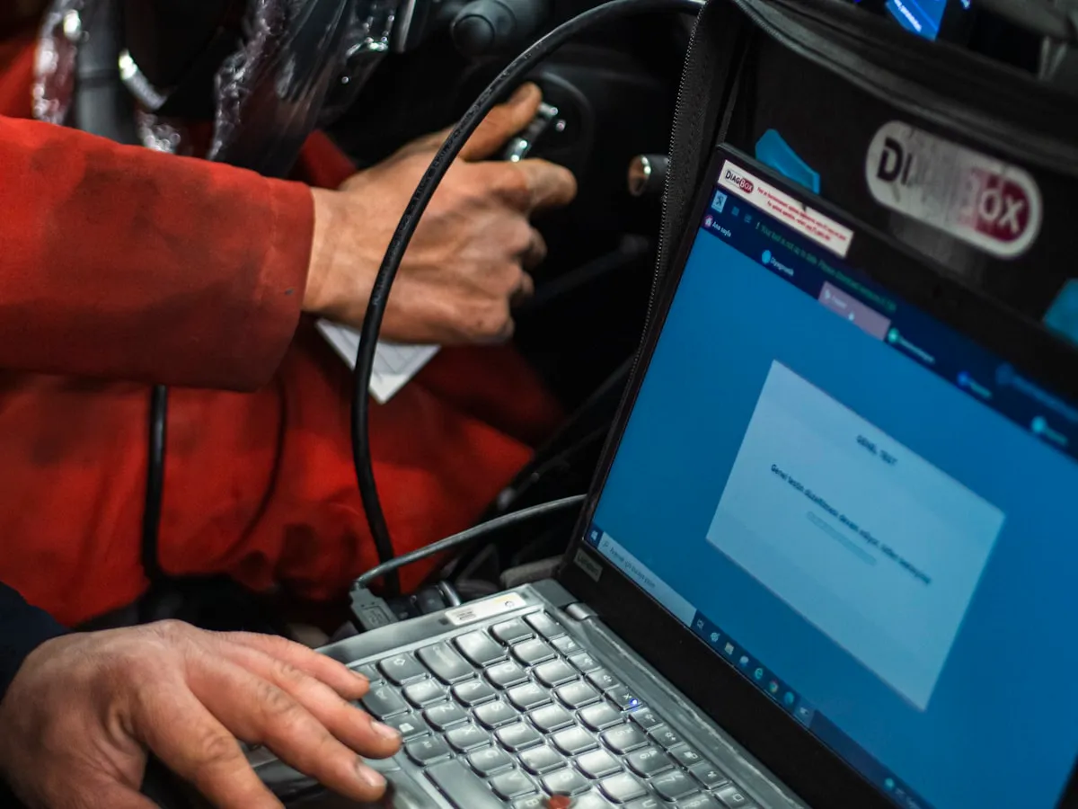 Laptop running vehicle diagnostics plugged into a car