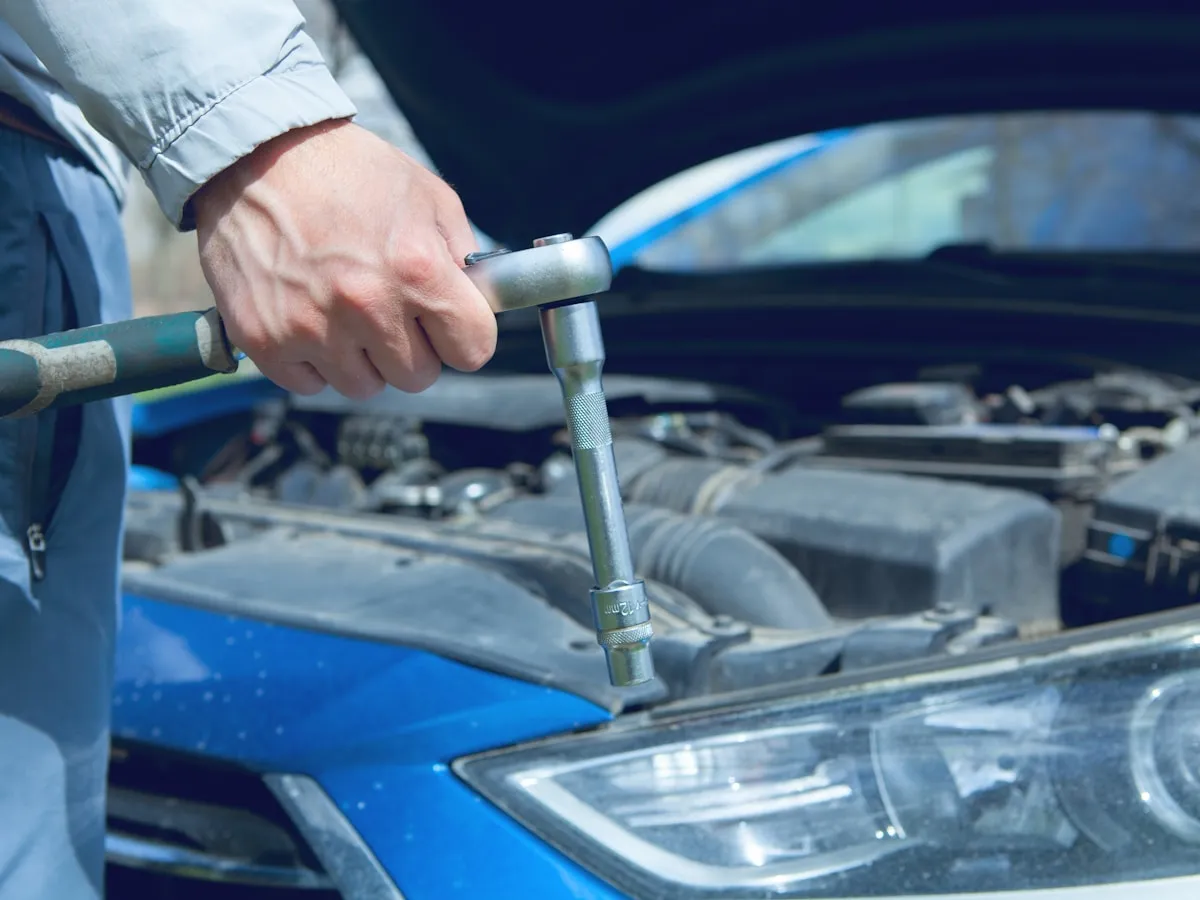 Mechanic working under the bonnet of a car during a full service